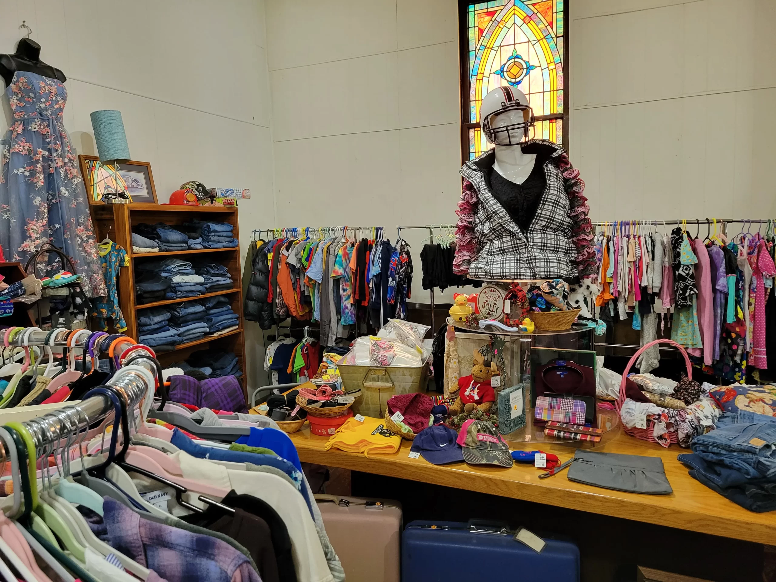 Clothing on racks and a table featuring accessories like hats and handbags